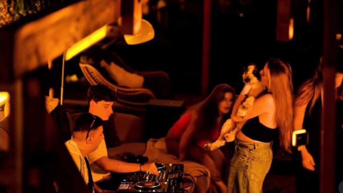 Warmly lit nightlife scene with a DJ and friends