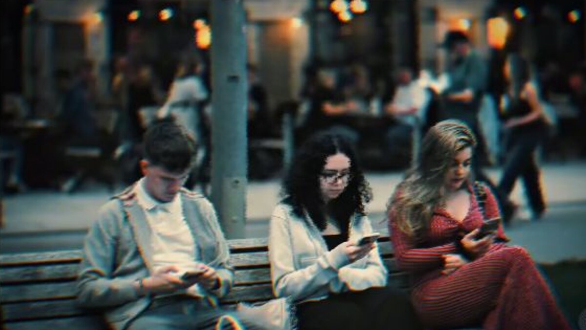 Three people sitting on a city bench in a cinematic frame